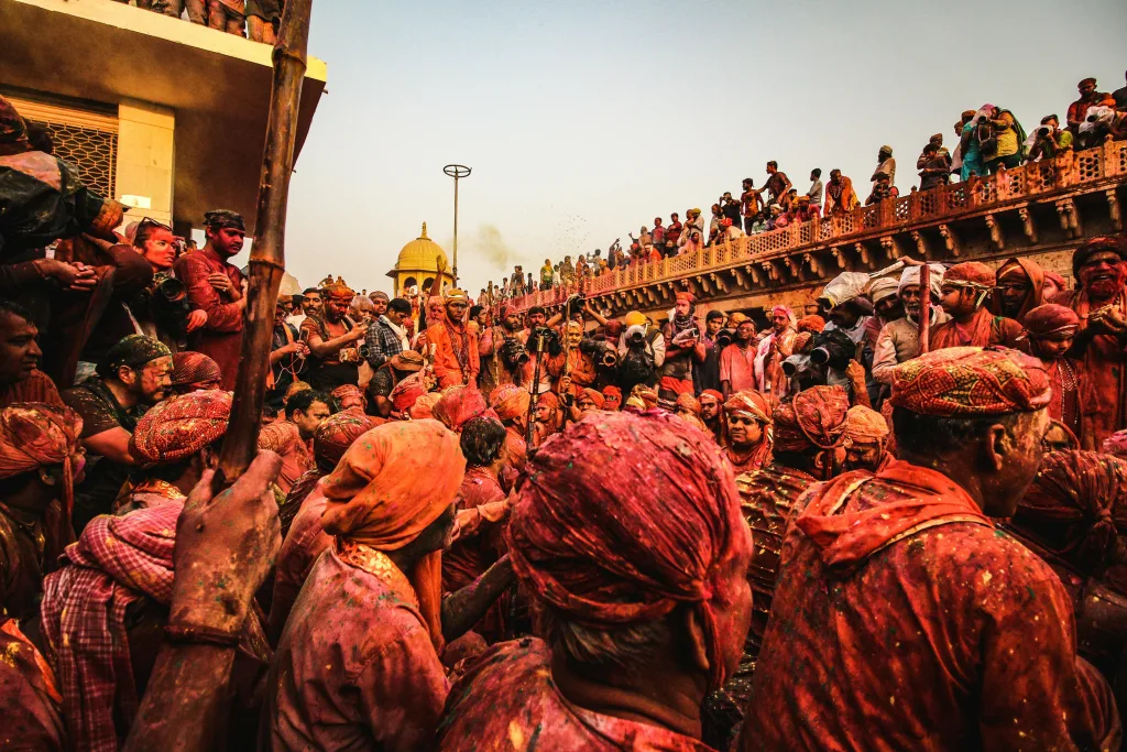 A lively crowd celebrating the colorful Holi festival with tradition and joy outdoors in India.