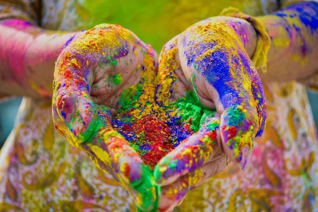 Close-up of colorful hands holding vivid Holi festival powder showcasing vibrant celebration.