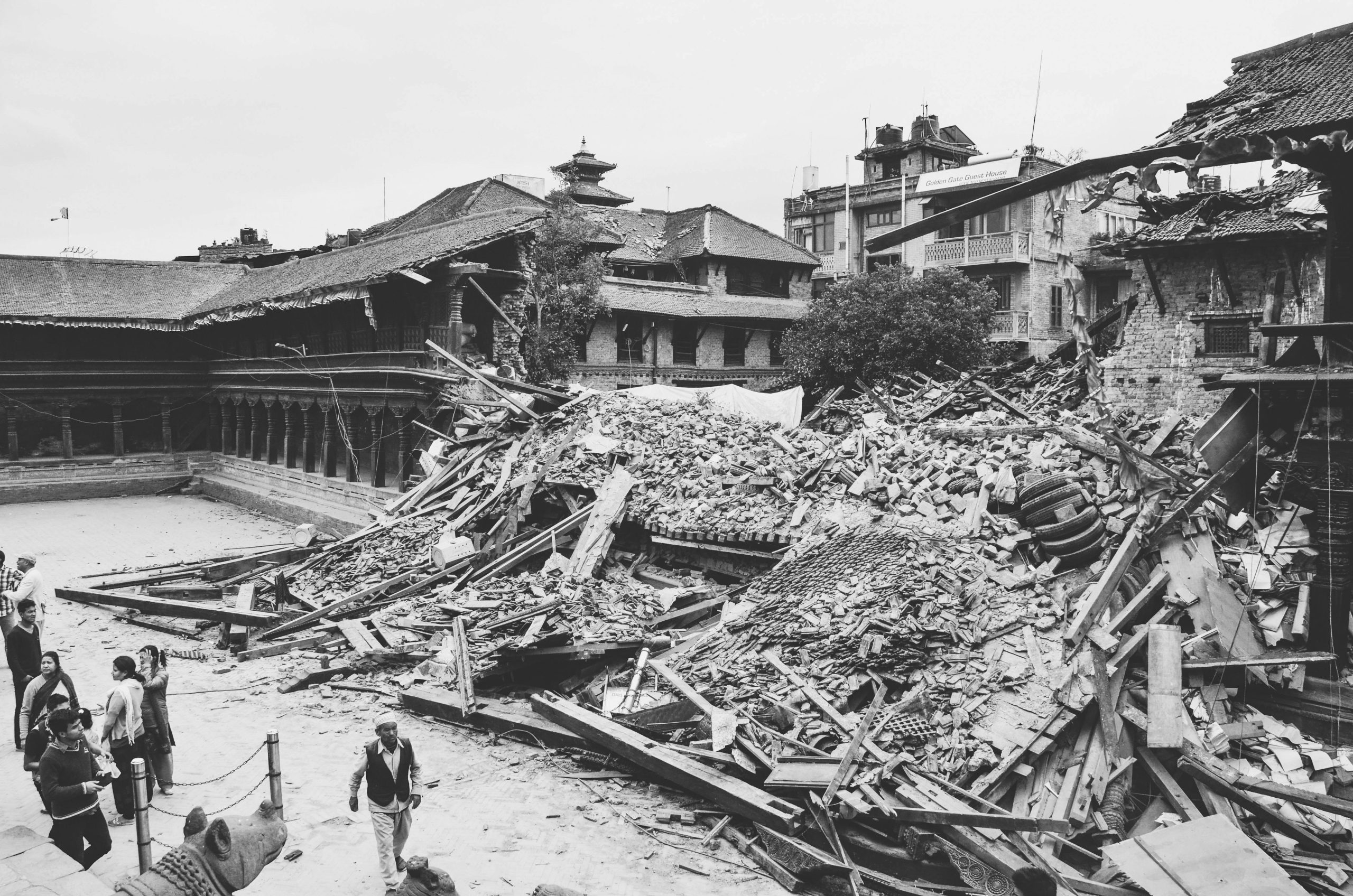 Monochrome image capturing earthquake aftermath in Bhaktapur, Nepal, showing destroyed buildings and debris.